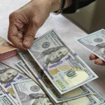 Gambar uang kertas Rupaih (IDR) dan uang kertas Dolar Amerika Serikat (USD).
