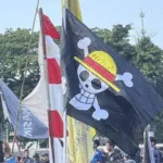 Bendera bajak laut One Piece dikibarkan di samping Bendera Merah Putih.