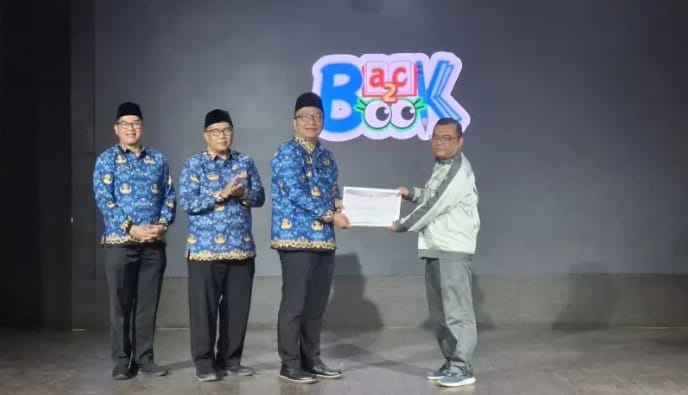 Pemberian pengharagaan oleh Plt. Bupati Gresik, Asluchul Alif kepada Yudi Darjanto, CSR Manager PT. BKMS